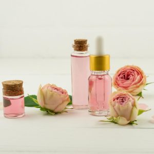 glass bottles with cork lid and rose water, cosmetic bottle with rose oil . white background
